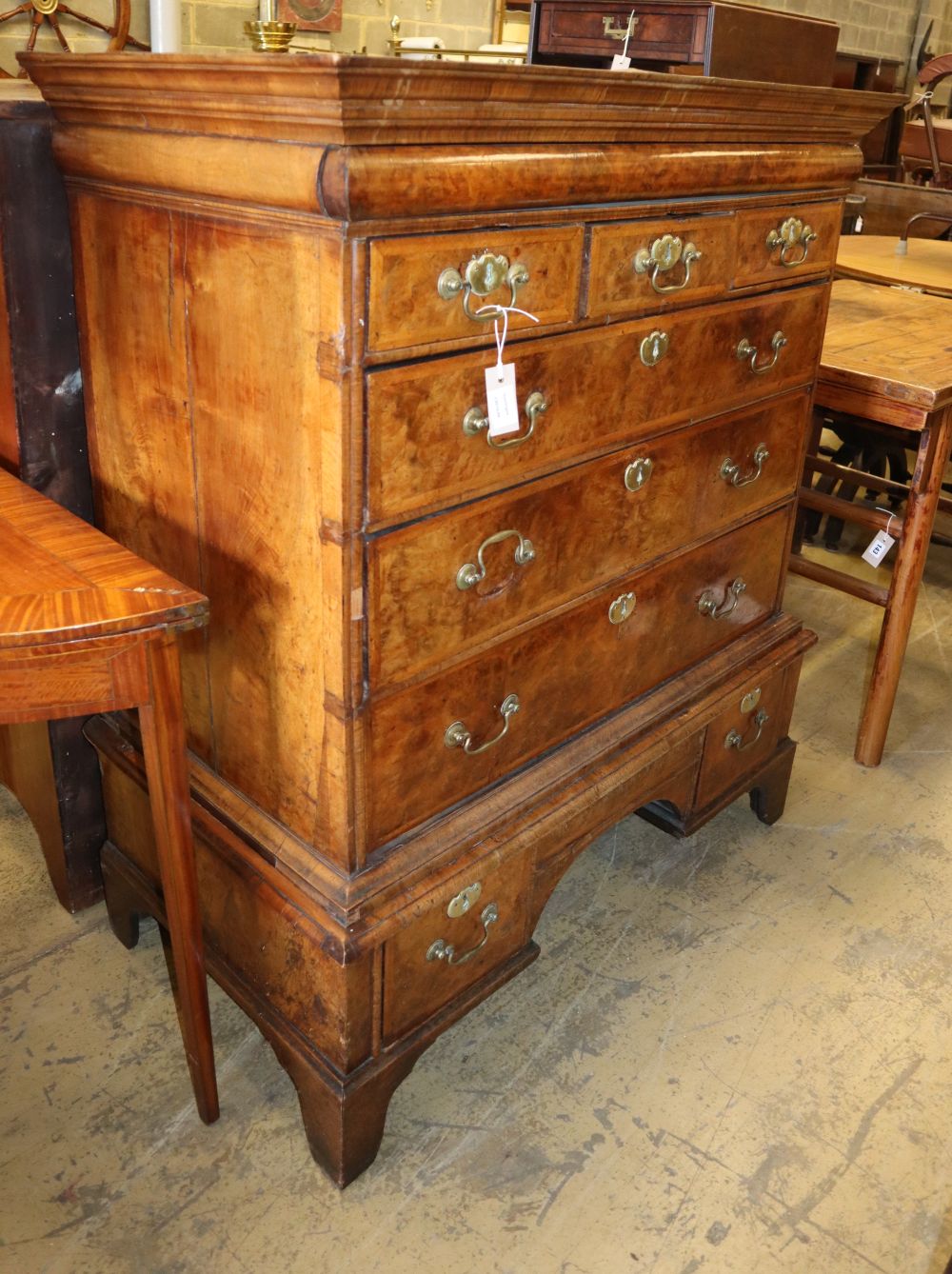 An early 19th century walnut and crossbanded chest on stand, later bracket feet, W.106cm, D.57cm, H.128cm
